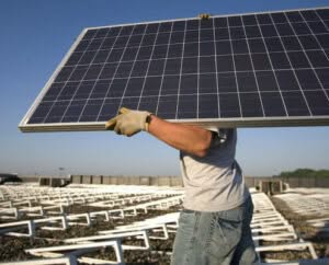 operaio che si occupa di disinstallare un impianto fotovoltaico vecchio per essere smaltito